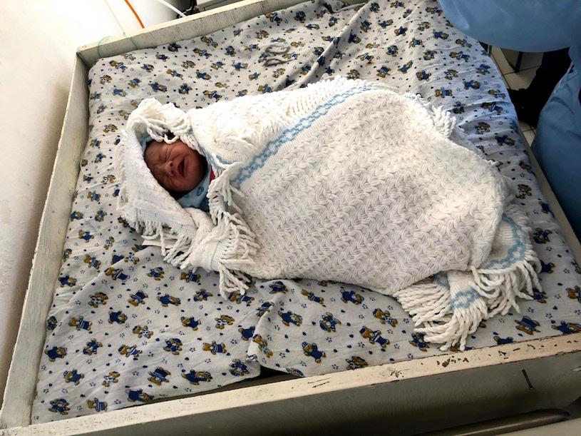 Newborn baby on a changing table.