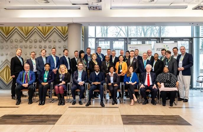 Eine südafrikanische Delegation steht und sitzt eine südafrikanische Delegation zum BETD in Berlin für ein Foto zusammen.