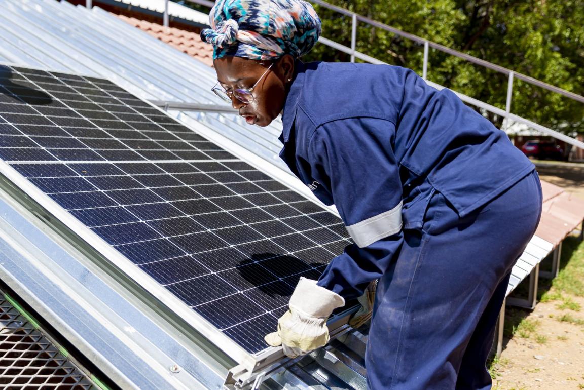 A woman installs PV system modules.