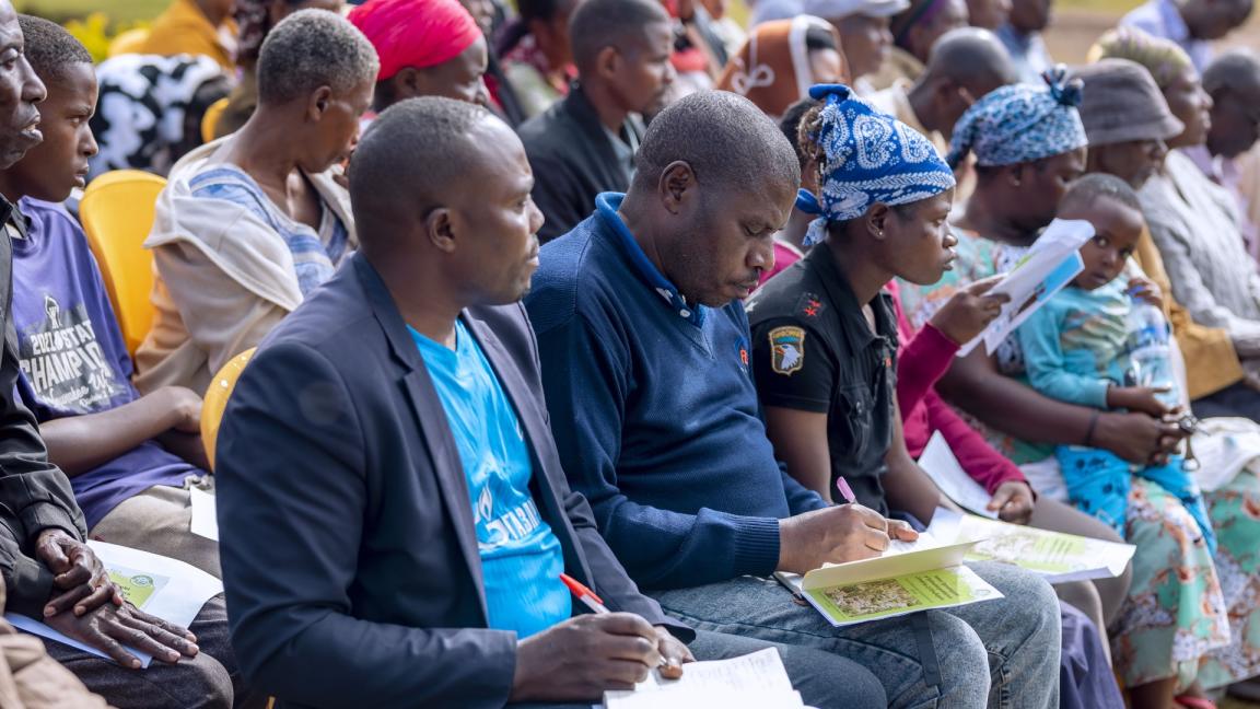 At a planning meeting, people sit in rows and take notes.