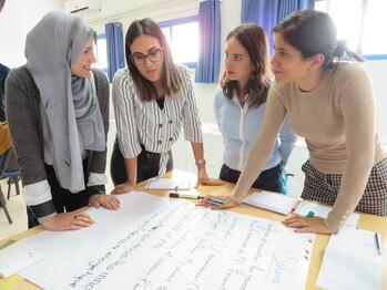 Vier Frauen stehen an einem Tisch