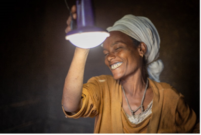 Eine Frau in Äthiopien nutzt eine solarbetriebene Lampe für ihr Zuhause.