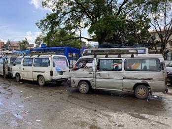 Kleinbusses mit deutlichen Gebrauchsspuren an einer Bushaltstelle.