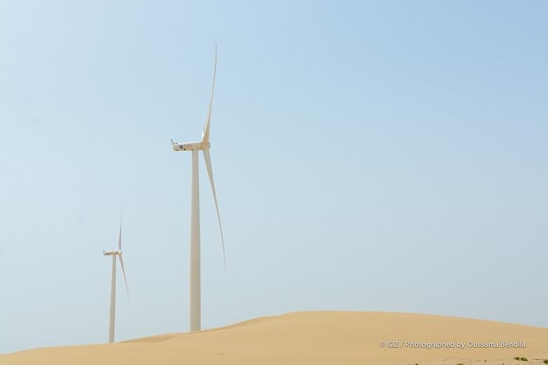 Zwei Windräder stehen in einer Wüste