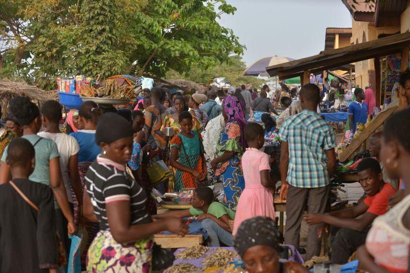De nombreuses personnes déambulent entre les stands d’un marché.