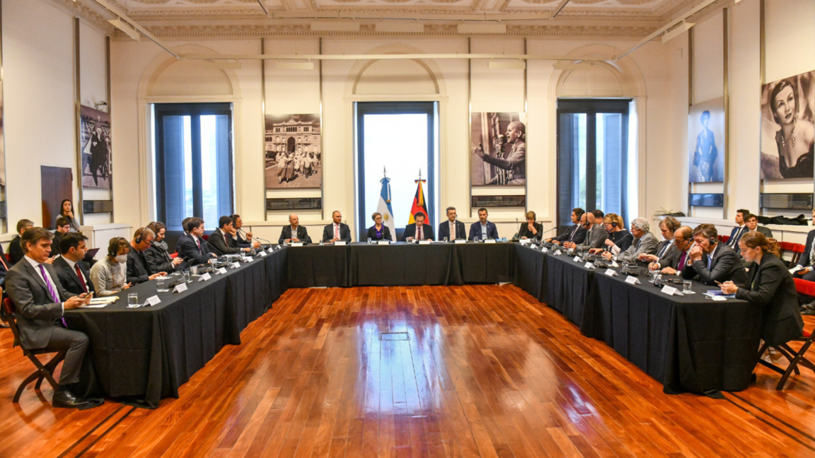 Key political figures hold discussions at long conference tables.