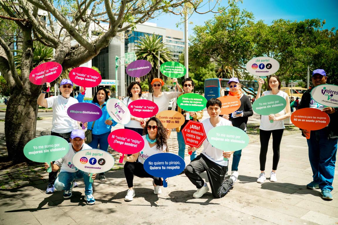 Participantes del bailetón por mujeres sin violencia en Quito sostienen letreros con mensajes para sensibilizar sobre la violencia contra las mujeres. 