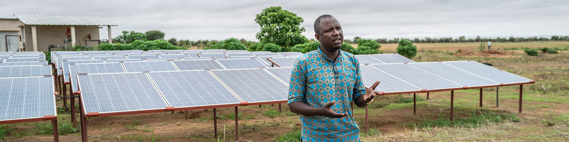 Ein Mann steht vor einer ländlichen Solaranlage. 