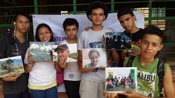 Sechs junge Menschen halten Fotos von vermissten Personen.