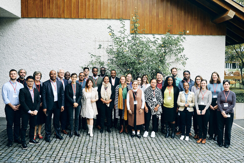 Die Teilnehmenden eines Partnermeetings posieren gemeinsam vor einem Haus.