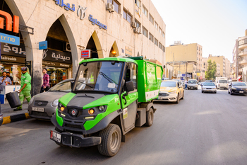 Ein elektrisches Müllfahrzeug fährt durch die Altstadt von Amman. Copyright: GIZ/Clemens Hess