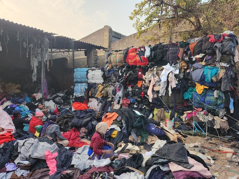 Sortieren, Trennen und Auseinandernehmen von weggeworfenen Textilien und Kleidungsstücken für das Recycling.