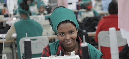 Eine junge Frau arbeitet an einer Nähmaschine. 
