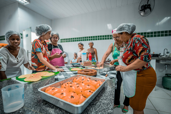 Frauen bereiten in der Küche einer städtischen Schule eine Mahlzeit zu.