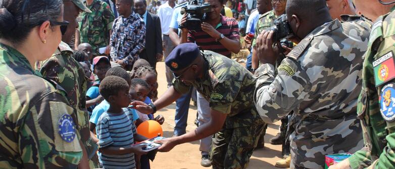 Mosambikanische Militärs und Soldaten der EU-Ausbildungsmission (EUTM) verteilen Lernmaterial an einheimische Schulkinder in Cabo Delgado.