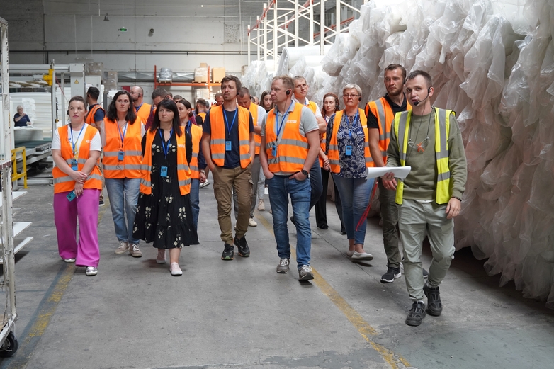 Menschen werden durch eine Fabrik geführt.