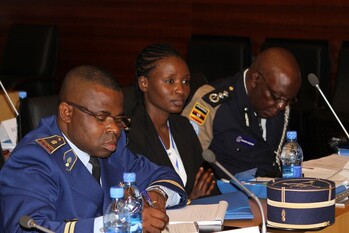 Bei einer Veranstaltung sitzen drei Polizeivertreter*innen an Konferenztischen.