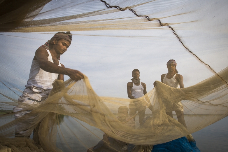 Drei Fischer halten ein Fangnetz in den Händen. Copyright: GIZ/Ranak Martin