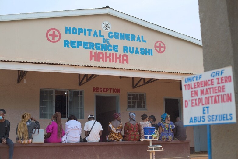 Menschen warten vor einem Krankenhaus in Ruashi, welches mithilfe der Steuereinnahmen aus dem Bergbau renoviert wurde. Copyright: GIZ