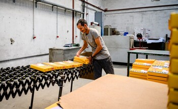 Ein Mann bedient eine Maschine in einer Fabrikhalle.