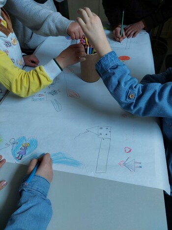 Kinder zeichnen gemeinsam ein Bild