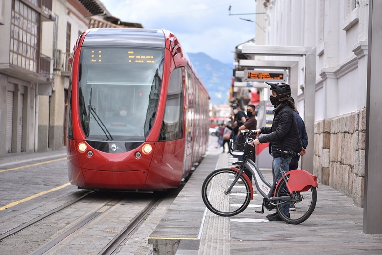 Eine elektrische Straßenbahn sowie ein elektrische Fahrrad in Cuenca, Ecuador