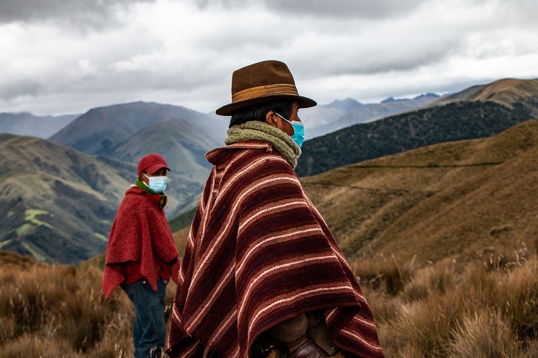 Zwei Männer in traditioneller Kleidung stehen im Anden-Hochgebirge. Foto: Rafael Jarrín