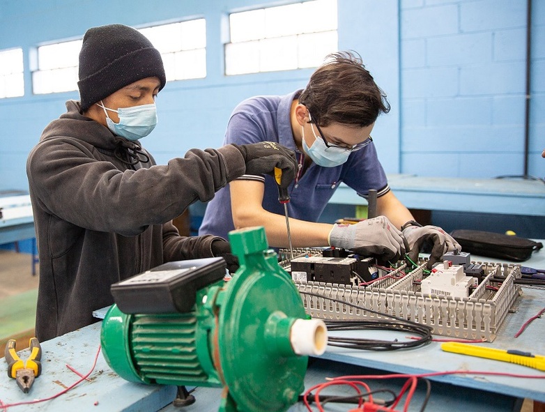 Zwei Schüler arbeiten in einer Werkstatt. Copyright: Mirena Martínez/ GIZ