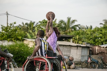 Eine Frau und ein Mann spielen draußen Rollstuhlbasketball  GIZ/Apelete Assogba