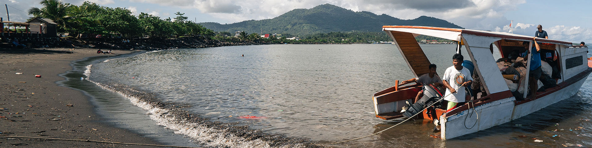 Ein Boot an der Küste von Manado bringt Plastikmüll aus dem Bunaken Nationalpark.