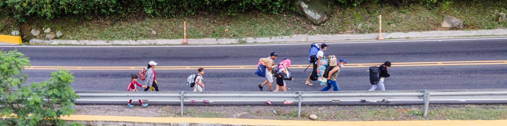 Menschen auf der Flucht laufen auf einer Straße.
