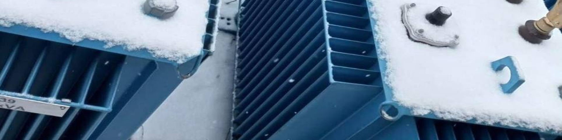 Schneebedeckte Energiespeicher in blauen Container stehen nebeneinander.
