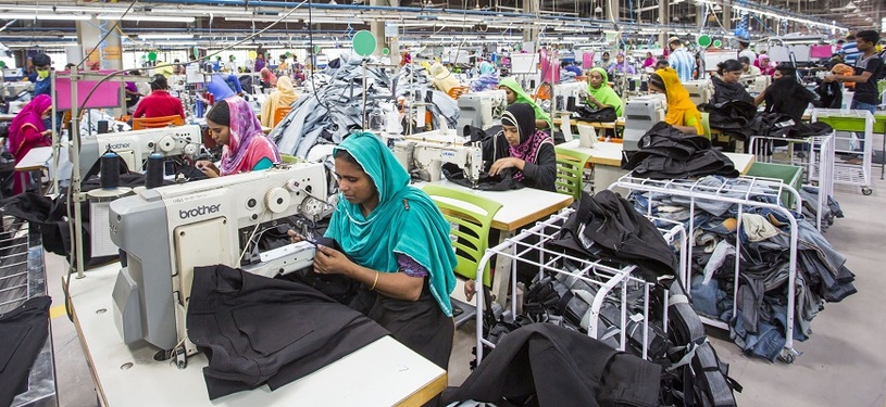 Mehrere Frauen nähen Kleidung in einer Fabrik.