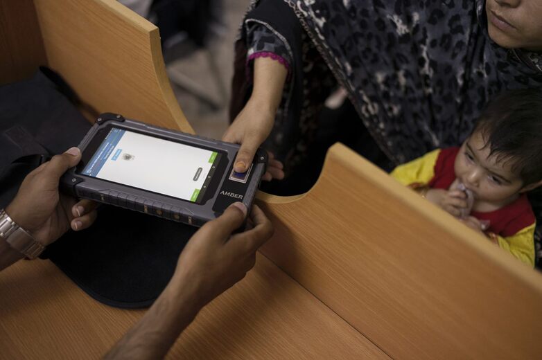 Eine Frau registriert sich mit ihrem Fingerabdruck direkt in das zentrale Sozialregister und kann sofort Unterstützung bekommen. 