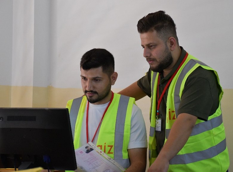 Zwei frischgebackene Absolventen bei einer Cash-for-Work-Maßnahme in einer Gemeinde