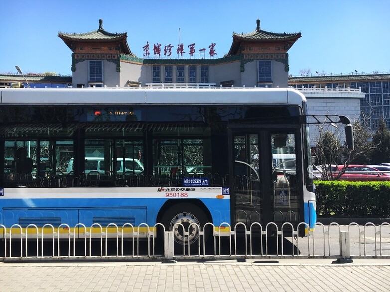 Vor einem Gebäude in China hält ein Bus.