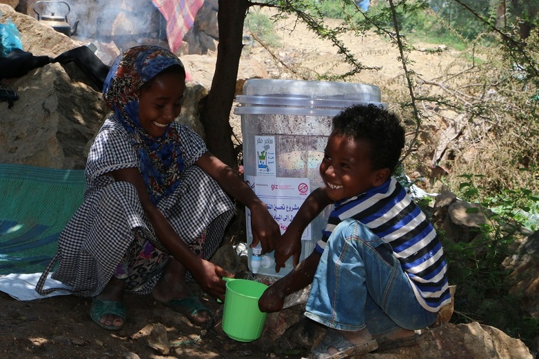 Binnenvertriebene und ortsansässige Kinder nutzen gemeinsam die vom Projekt übergebenen Trinkwasserfilter (Quelle: GWQ)
