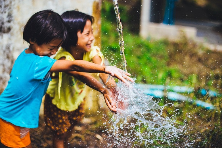 Zwei Kinder freuen sich über sauberes Wasser.