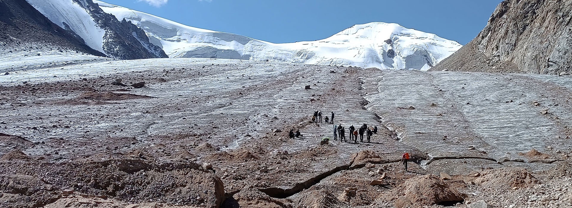 Ein Gletscher ist in einer kargen Berglandschaft.