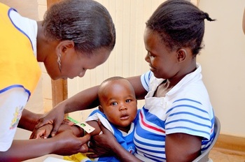 A nurse checks a baby during a routine visit