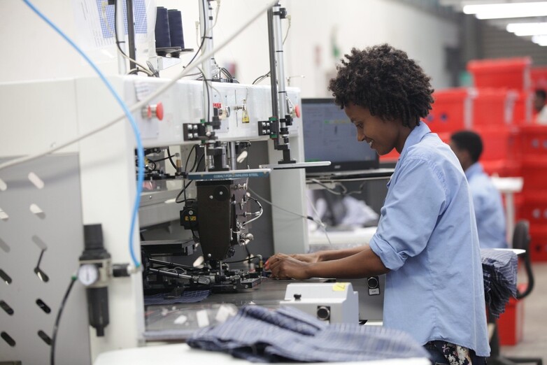 An employee in the industrial park working on machines that make clothing.