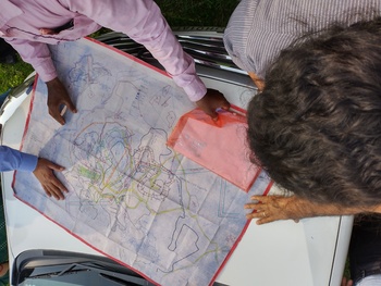 Four people looking at a map of the coal mines in Jharkhand (India).