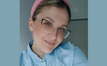 A woman wearing glasses and a pink headband.