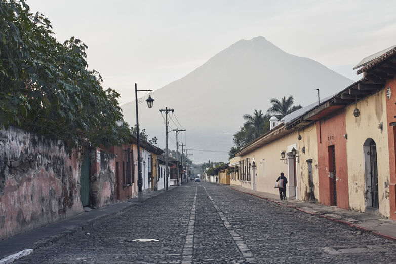 View of a street with a mountain in the backdrop.