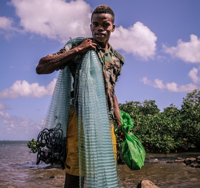A young person with a fishing net at work. 