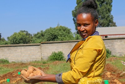 A woman holding potatoes in her hands.