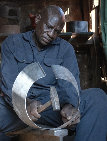 A person working on a metal object.