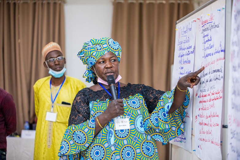 A lady presenting information on a chart.