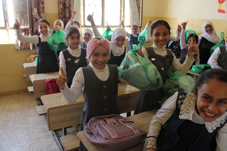Girls at a school receive new school uniforms.