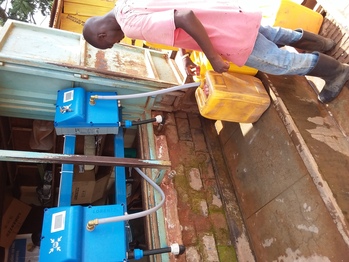 A man fills a water canister at a water kiosk. Copyright: GIZ/Amule James Michael